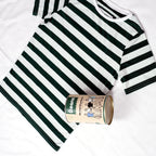 Beans green and white striped women's t-shirt next to reusable metal packaging can